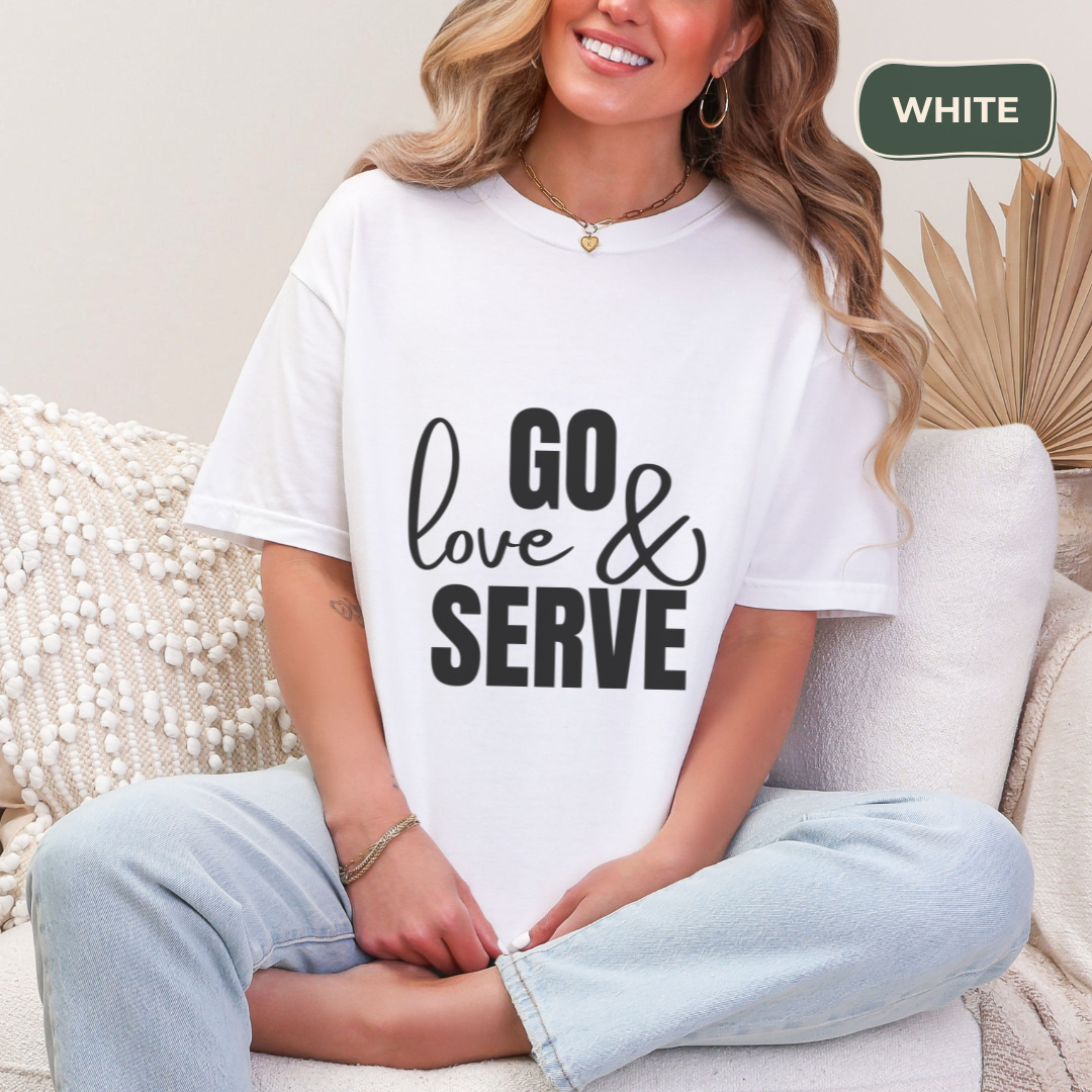 Person wearing a white t-shirt with 'GO love & SERVE' text, sitting on a couch.