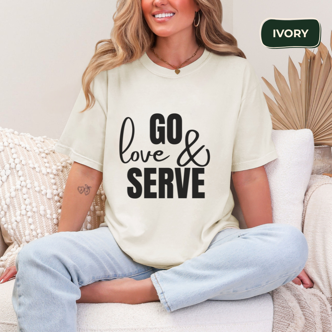 Woman wearing a white t-shirt with 'GO love & SERVE' text, sitting on a couch.