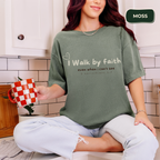 Person wearing a green t-shirt with text, holding a mug in a kitchen.